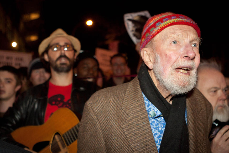 FILE- In this Oct. 21, 2011, file photo activist musician Pete Seeger, 92, right, marches with nearly a thousand demonstrators sympathetic to the Occupy Wall Street protests to hold a brief acoustic concert in New York’s Columbus Circle. The singer and activist, who revered the masses and declined any personal honors in life, will be celebrated with a few early events planned on what would have been his 95th birthday, Saturday, May 3, 2014. (AP Photo/John Minchillo, File)