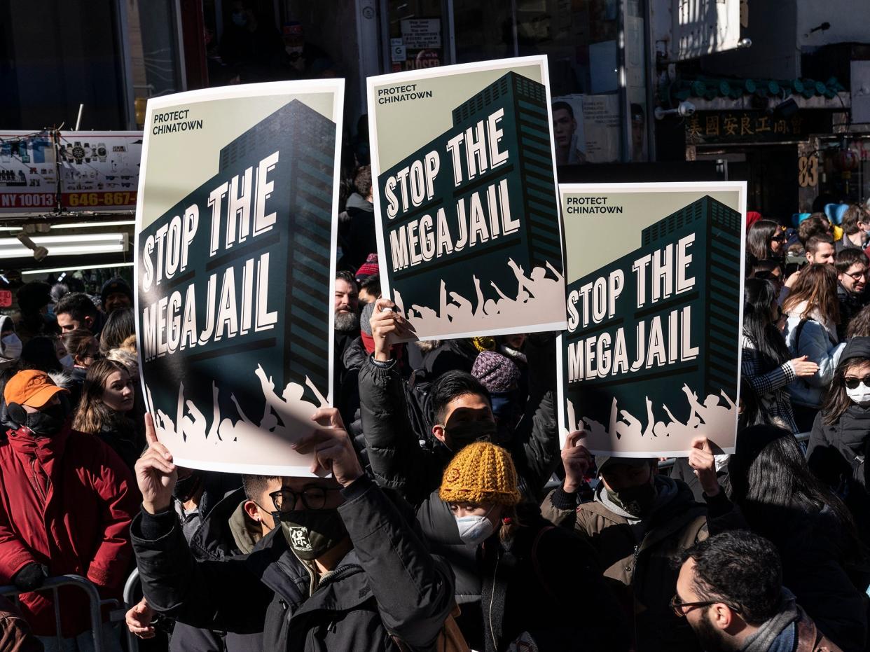 People with protest placards that read "Stop the Mega Jail" during a Lunar New Year parade in New York City's Chinatown.