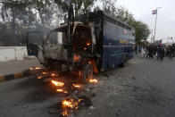 A police vehicle burns during an anti-government rally by supporters of Pakistan's key opposition party, in Karachi, Pakistan, Wednesday, May 25, 2022. Pakistani police have fired tear gas and scuffled with stone-throwing supporters of defiant former Prime Minister Imran Khan as they gathered for planned marches Wednesday toward central Islamabad for a rally he hopes will bring down the government and force early elections. (AP Photo/Fareed Khan)