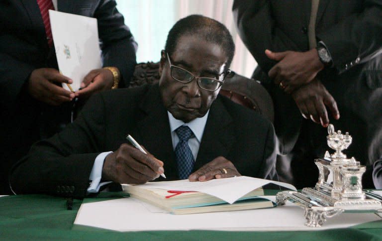 Zimbabwe President Robert Mugabe signs into law Zimbabwe's new constitution at the State House in Harare on May 22 2013, clearing the path to crucial elections later this year
