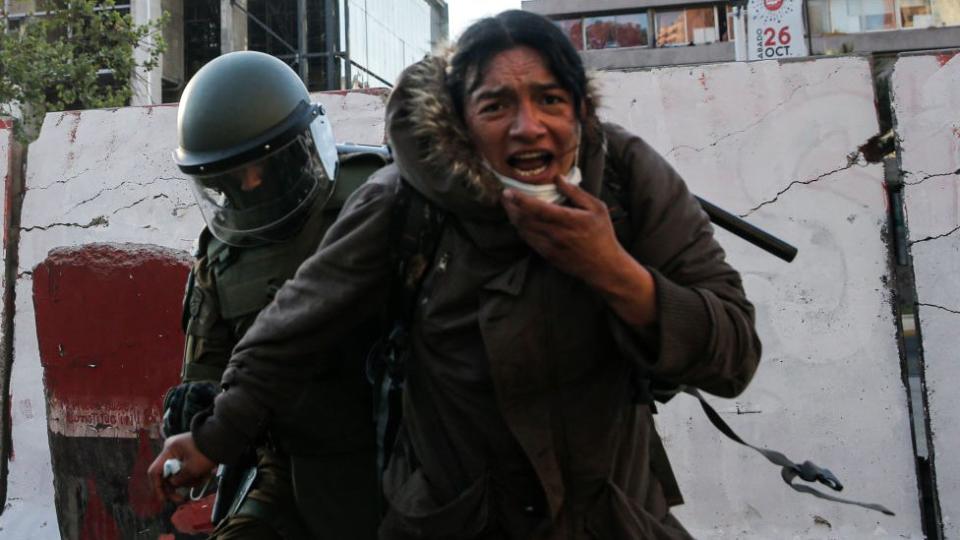 Manifestante durante las protestas de este sábado junto a un carabinero.