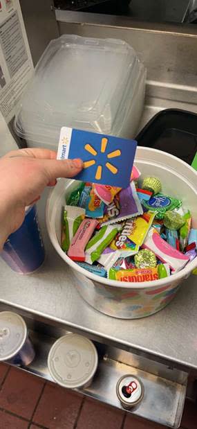 Lily LaRue holds a Walmart gift card above a bucket of Easter candy at the Lawrence, Kansas Applebee's. LaRue, a former server at the restaurant, said two Applebee's area directors visited the restaurant last week, after the leak of an email from an Applebee's franchisee executive. They brought staff $25 gift cards and candy.