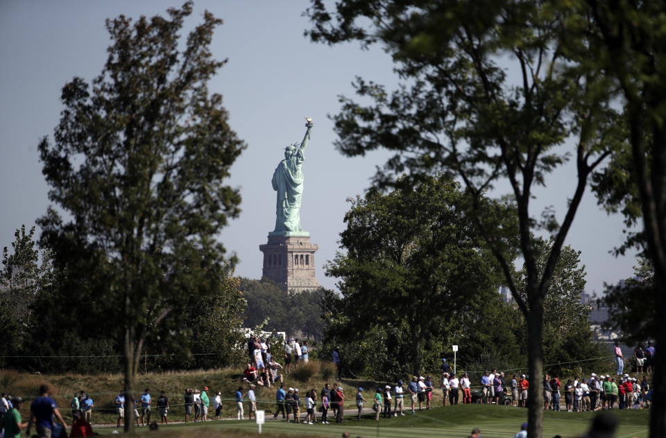 <p>The Statue of Liberty is shown as spectators walk down the second hole during the Presidents Cup foursomes golf matches at Liberty National Golf Club in Jersey City, N.J., Sept. 28, 2017. (Photo: Julio Cortez/AP) </p>