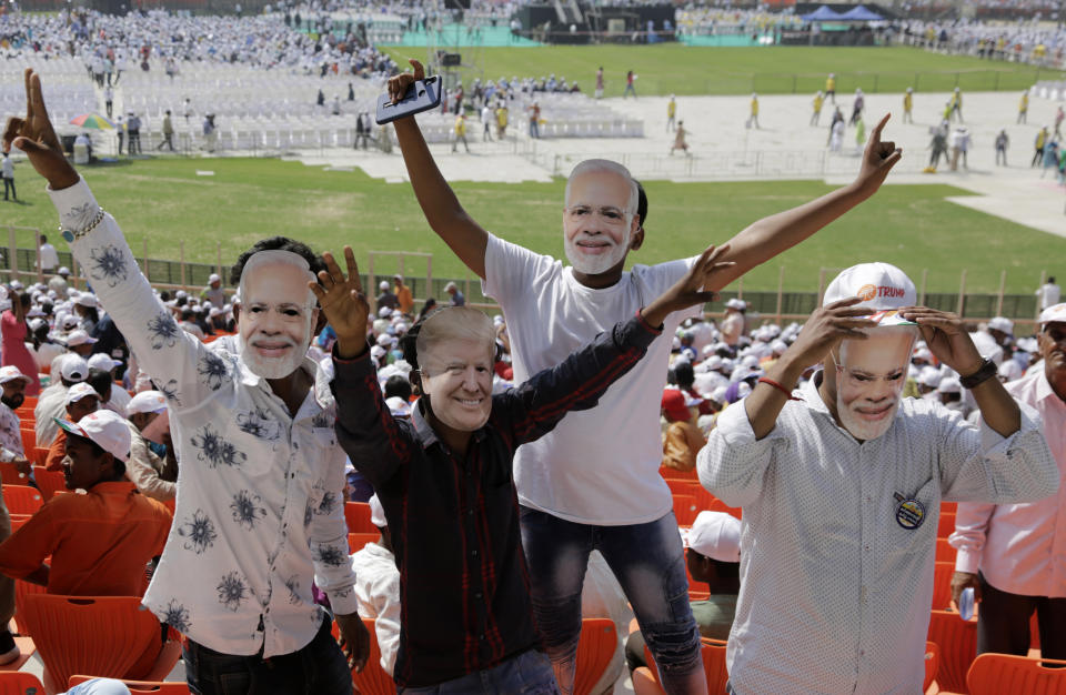 Indians wear masks of U.S. President Donald Trump and Indian Prime Minister Narendra Modi and cheer as they attend the Namaste Trump event at Sardar Patel Stadium in Ahmedabad, India, Monday, Feb. 24, 2020. Hundreds of thousands of people in the northwestern city are expected to greet Trump on Monday for a road show leading to a massive rally at what has been touted as the world's largest cricket stadium. (AP Photo/Ajit Solanki)