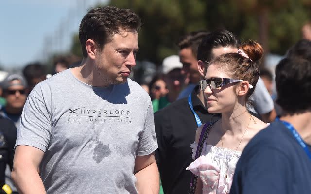 SpaxeX founder Elon Musk (L) and Canadian musician Grimes (Claire Boucher) attend the 2018 Space X Hyperloop Pod Competition, in Hawthorne, California on July 22, 2018. – Students from colleges and universities from the US and around the world are taking part in testing their pods on a 1.25 kilometer-long (0.75-mile) tubular test track at the SpaceX headquarters. (Photo by Robyn Beck / AFP) (Photo credit should read ROBYN BECK/AFP via Getty Images)