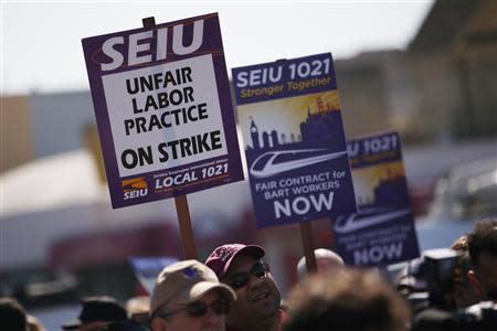 Demonstrators hold signs in support of striking Bay Area Rapid Transit (BART) workers outside Lake Merritt Station in Oakland, California October 18, 2013. REUTERS/Stephen Lam