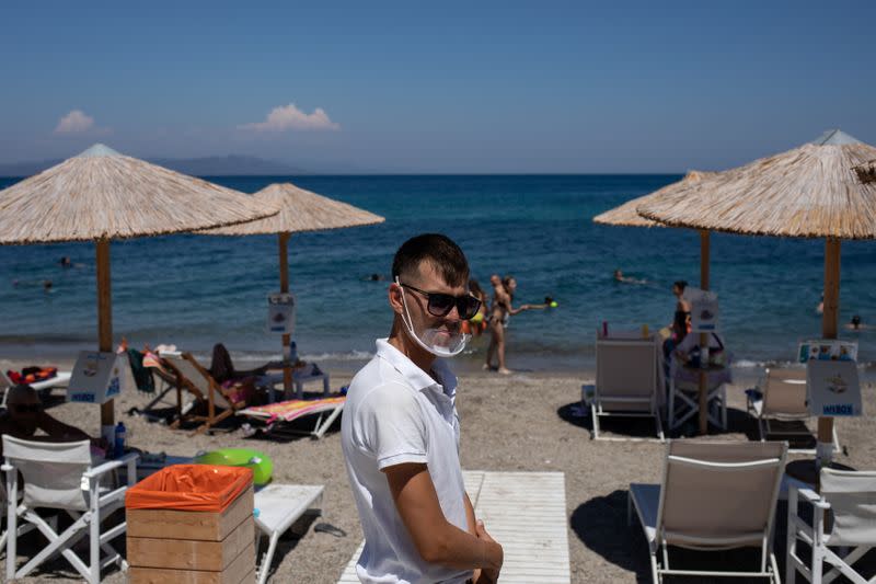 A waiter wears a protective face shield at a beach bar, following the coronavirus disease (COVID-19) outbreak, on the island of Kos