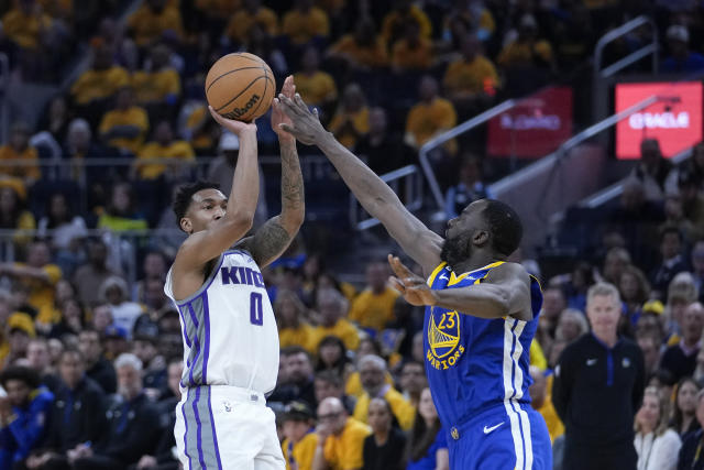 Sacramento Kings guard Malik Monk, left, looks to shoot over Golden State Warriors forward Draymond Green during the first half of Game 6 of a first-round NBA basketball playoff series in San Francisco, Friday, April 28, 2023. (AP Photo/Godofredo A. Vásquez)