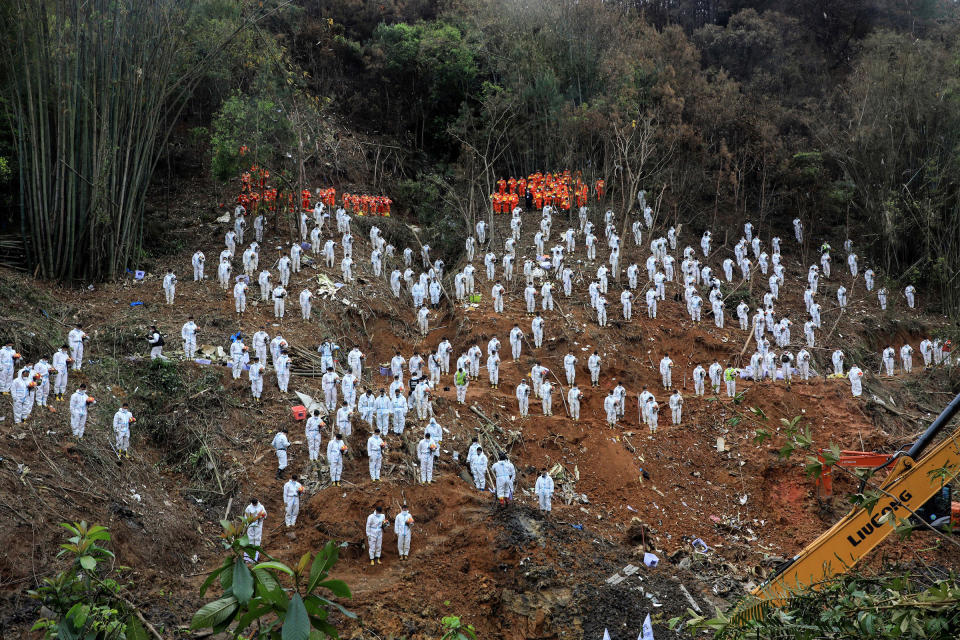 Rescuers stand in a silent tribute for victims at the site of the China Eastern Airlines plane crash in Tengxian county, Wuzhou city, in China's southern Guangxi region, on March 27.<span class="copyright">CNS/AFP/Getty Images</span>
