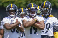 Pittsburgh Steelers wide receiver JuJu Smith-Schuster (19) center, holds a ball with teammates during a drill at an NFL football practice, Thursday, July 22, 2021, in Pittsburgh. (AP Photo/Keith Srakocic)