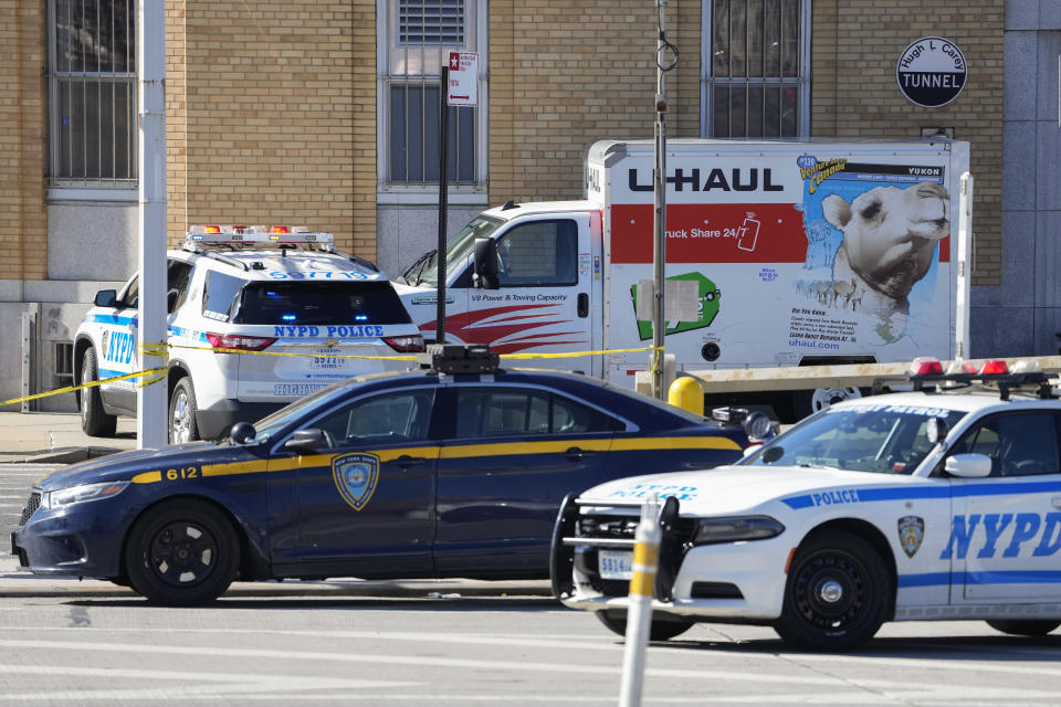 Police vehicles surround a U-Haul truck that struck cyclists, a pedestrian and a responding officer in Brooklyn on Monday, Feb. 13, 2023. / Credit: John Minchillo / AP