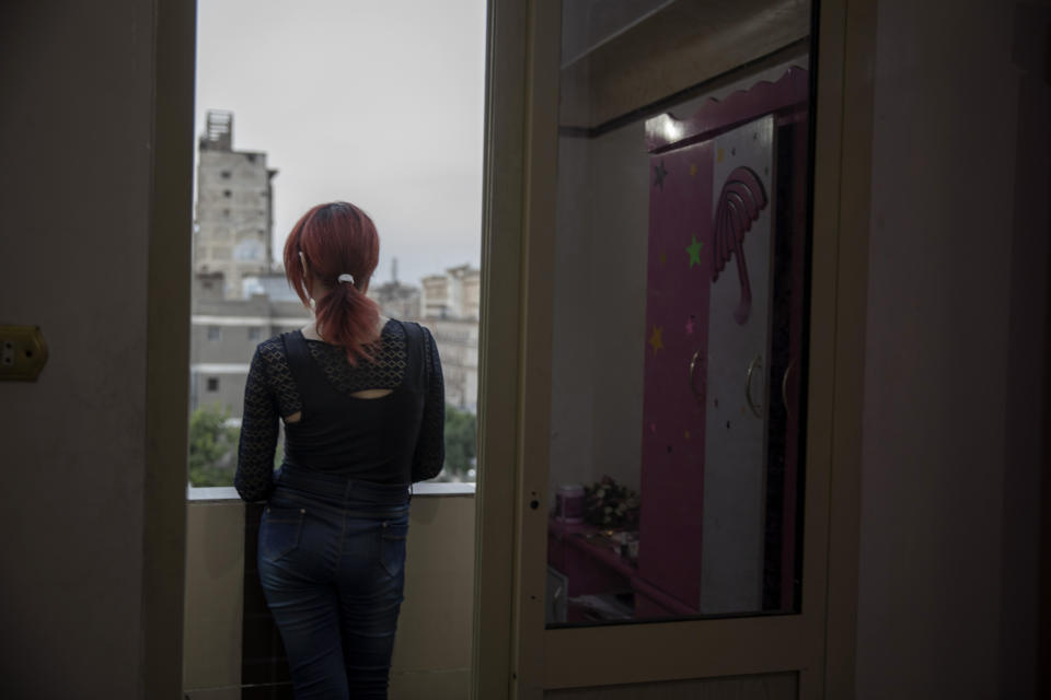 In this Oct. 28, 2019 photo, transgender woman Malak el-Kashif stands on her balcony as the sun sets, in Cairo, Egypt. Years of asking Who am I? "This was the hardest phase ever, even harder than confronting society, harder than prison," she said. "It was a huge fight that no one could protect me from." (AP Photo/Nariman El-Mofty)