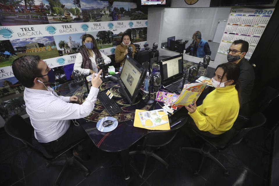 Teachers impart a lesson, broadcast through Bacata Stereo radio station, during the lockdown to prevent the spread of the new coronavirus in Funza, Colombia, Wednesday, May 13, 2020. Education ministries have developed online learning platforms for use by students with internet access, but many countries also are investing in broadcasting to reach low-income communities. (AP Photo/Fernando Vergara)