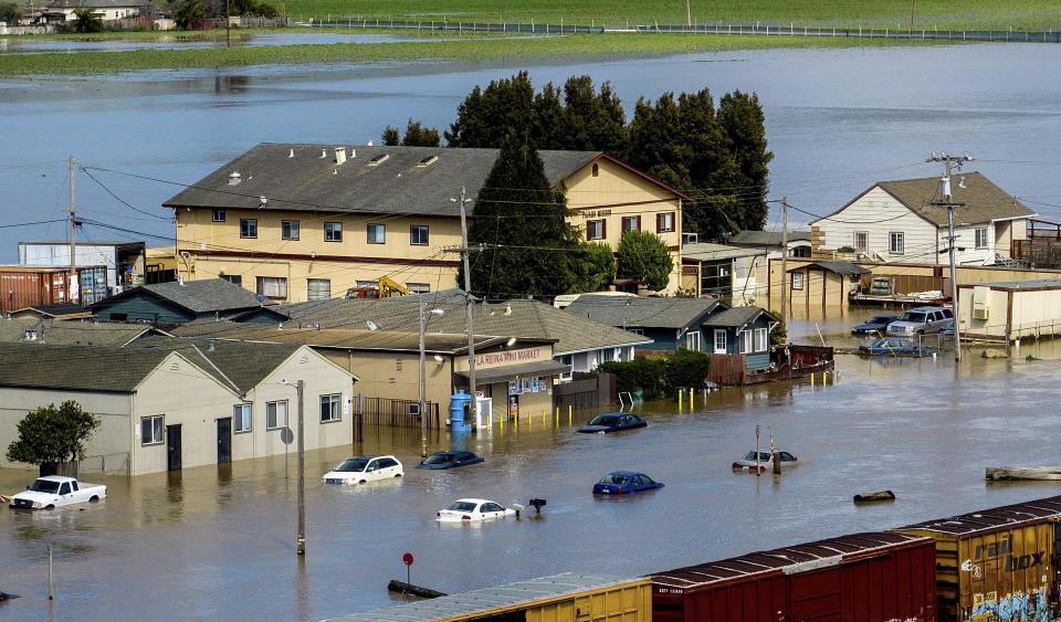 Floodwaters surround homes and vehicles in the community of Pajaro in Monterey County, Calif., on Monday, March 13, 2023. (AP Photo/Noah Berger)