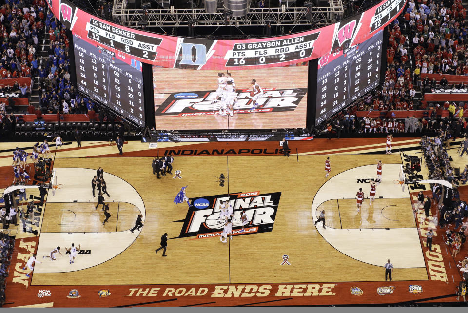 FILE - In this Monday, April 6, 2015, file photo, Duke players celebrate on the court after their 68-63 victory over Wisconsin in the NCAA Final Four college basketball tournament championship game in Indianapolis. The NCAA announced Monday, Jan. 4, 2020, that this year's 67 men's basketball tournament games including the Final Four will be played entirely in Indiana.(AP Photo/David J. Phillip, File)