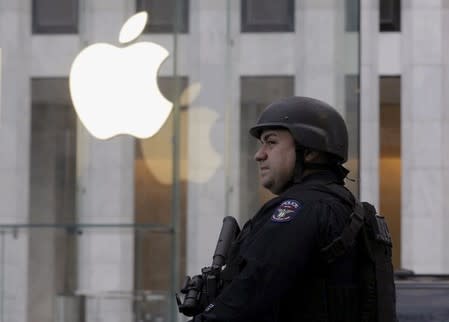 A New York City Police (NYPD) officer stands across the street from Apple Store on 5th Avenue in New York, in this file picture taken March 11, 2016. REUTERS/Brendan McDermid/Files