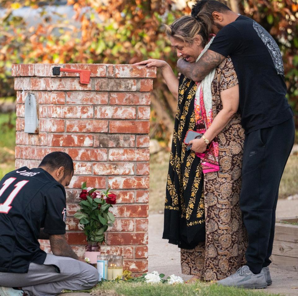 Family members mourn at a memorial set up in front of the home of a woman who was shot on Shadywood Drive in Austin, part of a multi-county wave of violence that left six dead and three injured.