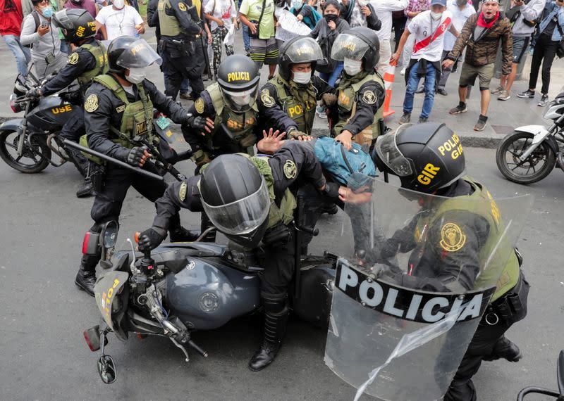 Police try to detain a man during protests after Peru's interim President Manuel Merino was sworn in following the removal of President Martin Vizcarra, in Lima