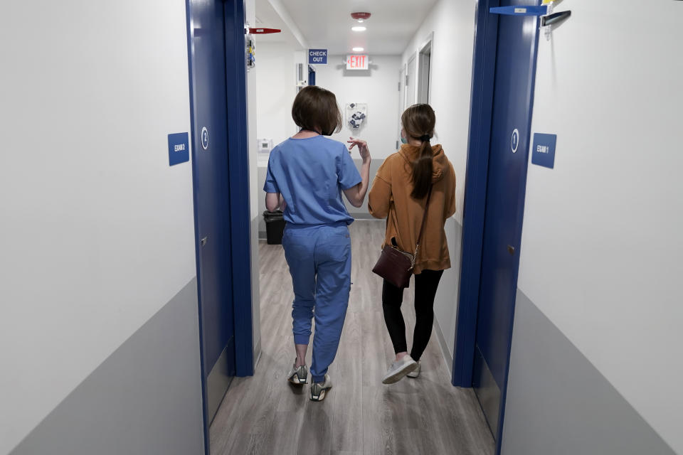 Dr. Elizabeth Brett Daily, left, walks with patient Haley Ruark after providing a medical abortion at a Planned Parenthood clinic Wednesday, Oct. 12, 2022, in Kansas City, Kan. (AP Photo/Charlie Riedel)