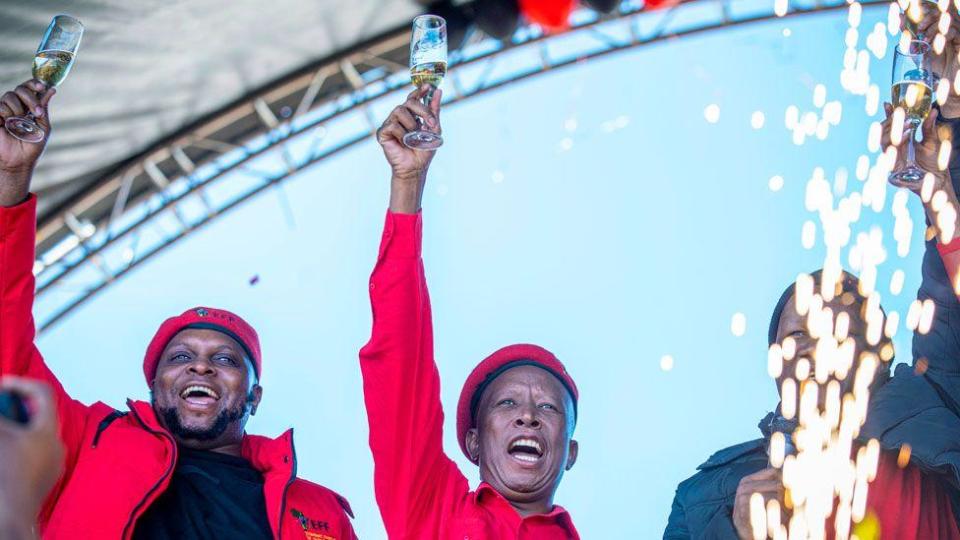 Floyd Shivambu (left) and Julius Malema (center) hold up champagne glasses during the EFF's 11th anniversary event in Kimberley, South Africa - July 27, 2024