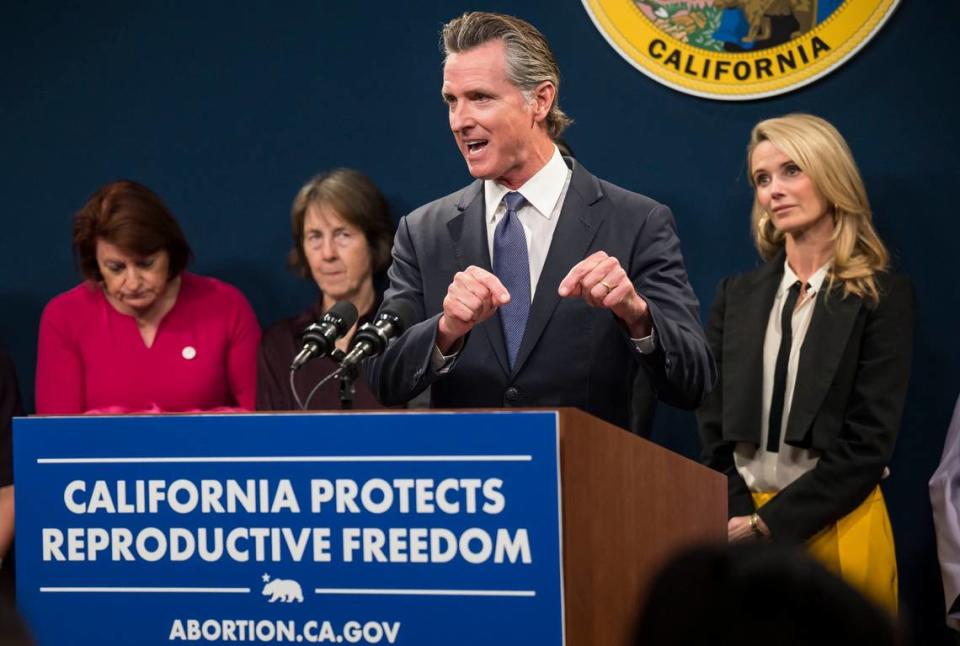 Gov. Gavin Newsom speaks Tuesday, April 18, 2023, at the Capitol swing space in Sacramento on actions the state is taking to protect women’s reproductive rights. Over his shoulder, from left, Senate President Pro Tem Toni Atkins, D-San Diego, Sen. Nancy Skinner, D-Berkeley, and First Partner Jennifer Siebel Newsom stand after giving their own remarks — along with reproductive rights stakeholders — at the news conference held the day before an anticipated U.S. Supreme Court ruling on abortion medication.