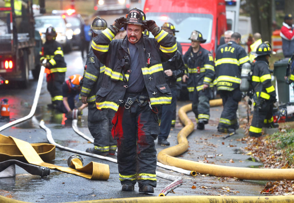 Woodbridge firefighters work the scene of fire after a plane crashed into a home located at 84 Berkeley Ave. Tuesday, Oct. 29, 2019, in Woodbridge,N.J. (AP Photo/Noah K. Murray)