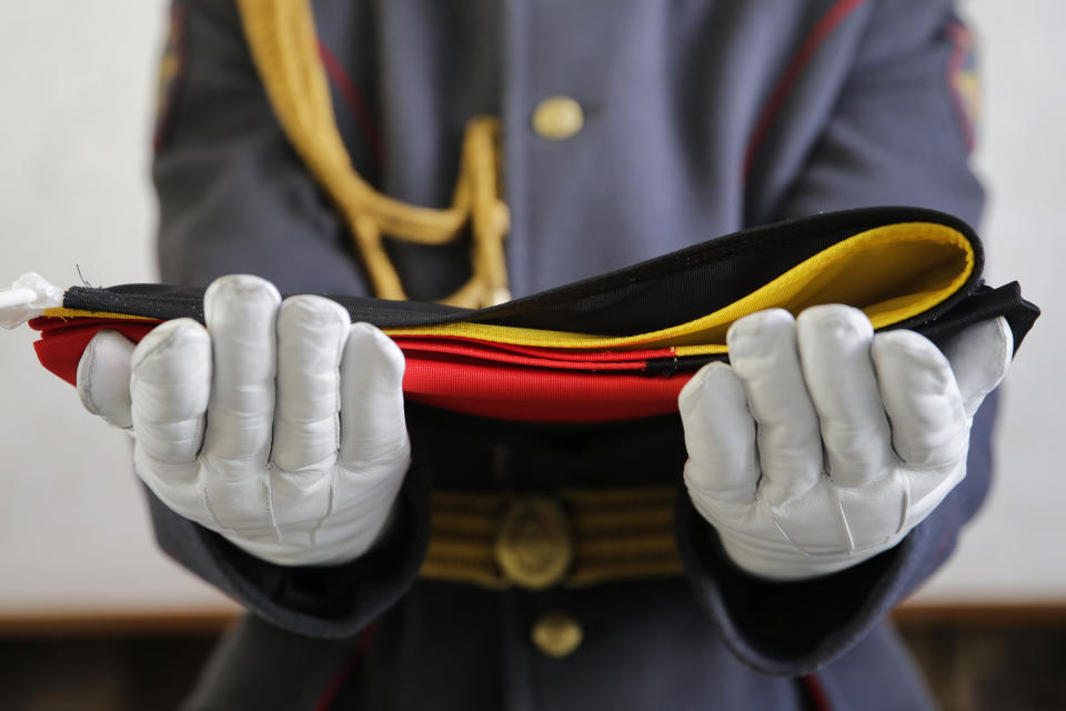 A member of Russian honor guard holds a German flag before a welcome ceremony for the German Olympic team at the Mountain Olympic Village prior to the 2014 Winter Olympics, Wednesday, Feb. 5, 2014, in Krasnaya Polyana, Russia. (AP Photo/Jae C. Hong)