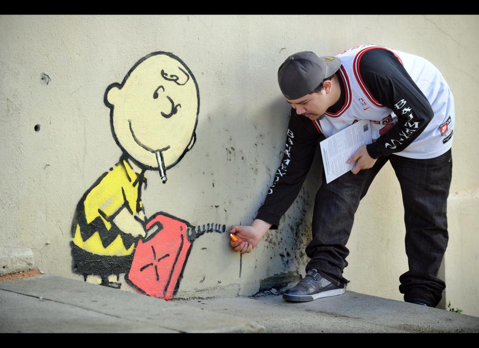 A graffiti attributed to secretive British artist Banksy depicting Charlie Brown figure starting a fire on the side of a burned-out building on Sunset Boulevard in Los Angeles, California on February 17, 2011. An other graffiti was ripped down in Hollywood, amid sightings of other pieces in a reported pre-Oscars publicity stunt in LA. Banksy is nominated for best documentary for 'Exit Through the Gift Shop' at the Oscars, due to be announced on February 27 at the climax of Tinseltown's annual awards season.  AFP PHOTO / GABRIEL BOUYS (Photo credit should read GABRIEL BOUYS/AFP/Getty Images)