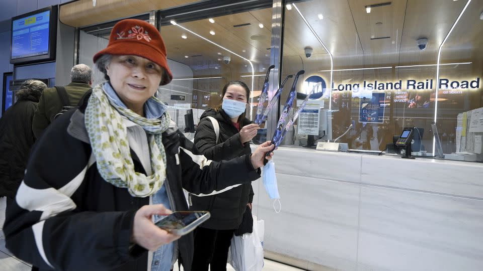 Michelle Eng and Pichnaieu Chung show of their free pairs of solar eclipse glasses after picking them up at the MTA Long Island Rail Road ticket window inside the Moynihan Train Hall, New York, NY, April 1, 2024. The solar eclipse is scheduled to occur on April 8th, 2024. - Anthony Behar/Sipa USA/AP