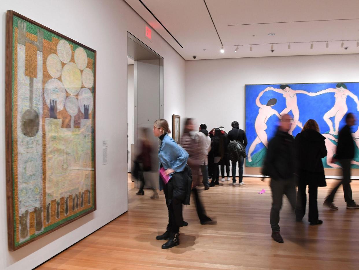 Visitors look at artwork by Iranian painter and sculptor Charles Hossein Zenderoudi -- K+L+32+H+4 Mon pere et moi, 1962' (L) -- at MoMA: Getty images