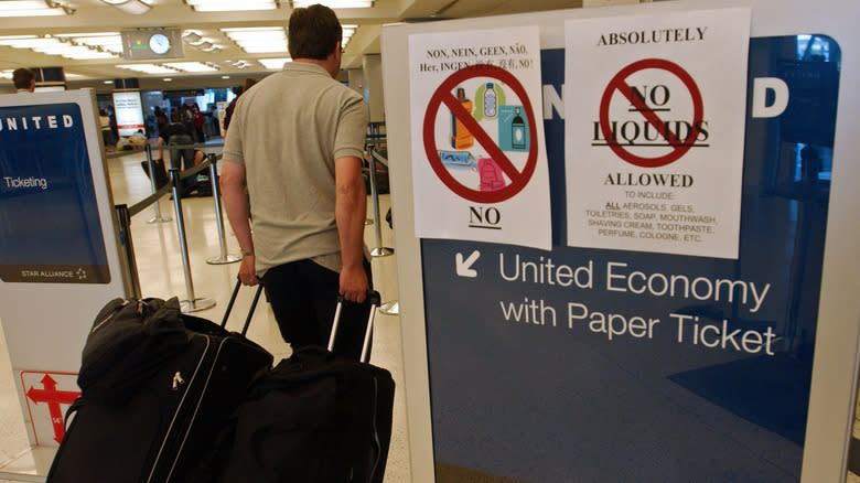 man walking into tsa line with luggage