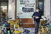 A man carries his meal past an advertisement promoting imported beef from Australia in Beijing, Monday, Nov. 23, 2020. China has stirred controversy with claims it has detected the coronavirus on packages of imported frozen food. (AP Photo/Ng Han Guan)