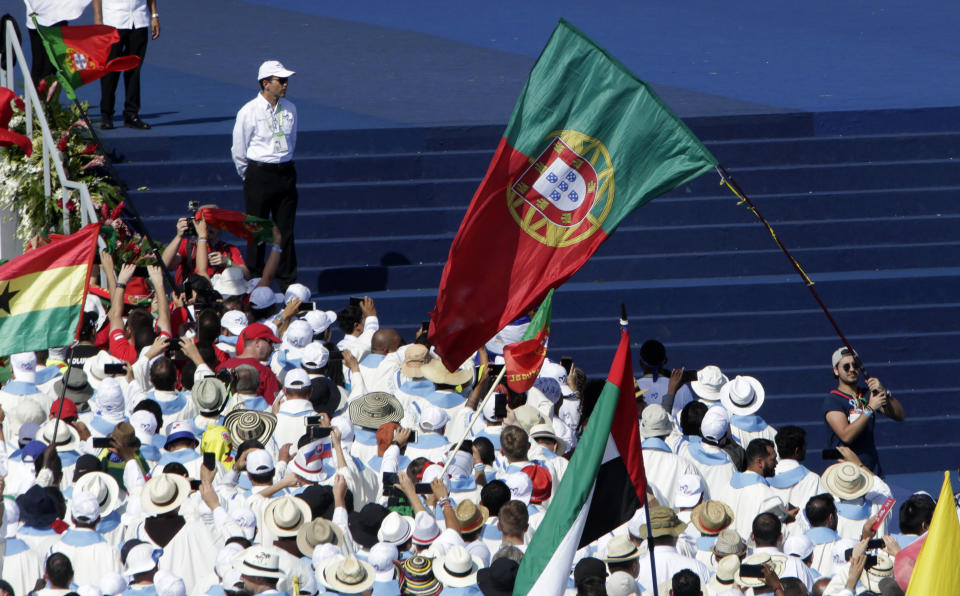 A youth waves a Portugal national flag during an early morning Mass marking the formal end to World Youth Day at the metro park Campo San Juan Pablo II in Panama City, Sunday, Jan. 27, 2019. The Roman Catholic Church's next World Youth Day will take place in Lisbon, Portugal in 2022. (AP Photo/Arnulfo Franco)