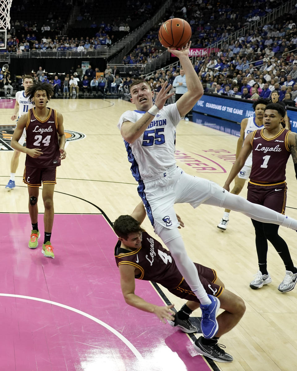 Creighton guard Baylor Scheierman (55) gets past Loyola Chicago guard Braden Norris (4) to put up a shot during the first half of an NCAA college basketball game Wednesday, Nov. 22, 2023, in Kansas City, Mo. (AP Photo/Charlie Riedel)