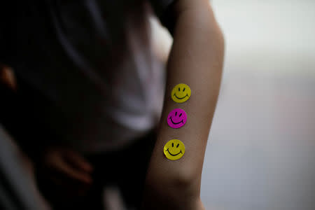 A child shows smiley stickers he received after taking a blood test sample during a health program of the NGO "Comparte por una vida" (Share for a life) at La Frontera school in Cucuta, Colombia February 5, 2019. Picture taken February 5, 2019. REUTERS/Marco Bello