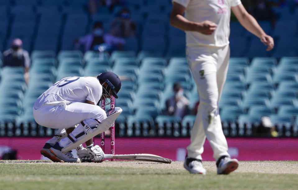 India's Ravichandran Ashwin,left, reacts after he was hit while batting during play on the final day of the third cricket test between India and Australia at the Sydney Cricket Ground, Sydney, Australia, Monday, Jan. 11, 2021. (AP Photo/Rick Rycroft)