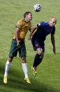 Australia's Alex Wilkinson (L) and Arjen Robben of the Netherlands jump for the ball during their 2014 World Cup Group B soccer match at the Beira Rio stadium in Porto Alegre June 18, 2014. REUTERS/Marko Djurica (BRAZIL - Tags: SOCCER SPORT WORLD CUP)