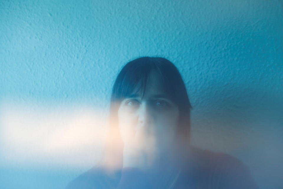 Long COVID sufferer Amaia Artica, a 42-year-old nursery school worker, poses for a photograph taken through blue plastic, in Pamplona, Spain, March 16, 2021. REUTERS/Susana Vera