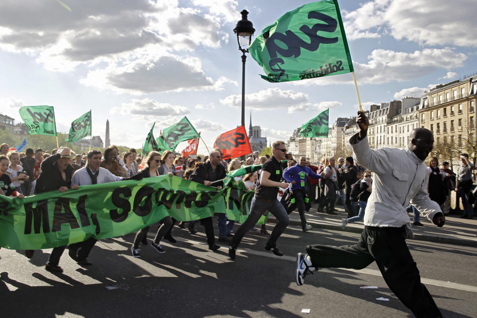 Demonstrators run on a bridge in Paris, during the traditional May Day march, Tuesday, May 1, 2012. Tens of thousands of workers, leftists and union leaders around France are marking May Day with marches and rallies, in an ambiance of optimism ahead of presidential elections Sunday that a Socialist is expected to win. (AP Photo/Laurent Cipriani)