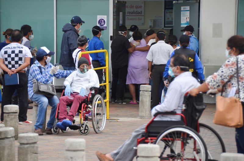 A woman is helped to enter the emergency room of Guasmo Sur General Hospital after Ecuador reported new cases of coronavirus disease (COVID-19), in Guayaquil