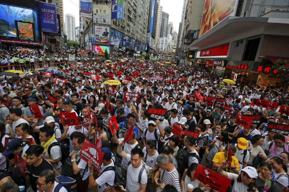 FILE - Protesters hold placards march on a street as they take part in a rally against the proposed amendments to extradition law in Hong Kong on June 9, 2019. When the British handed its colony Hong Kong to Beijing in 1997, it was promised 50 years of self-government and freedoms of assembly, speech and press that are not allowed Chinese on the Communist-ruled mainland. As the city of 7.4 million people marks 25 years under Beijing's rule on Friday, those promises are wearing thin. Hong Kong's honeymoon period, when it carried on much as it always had, has passed, and its future remains uncertain, determined by forces beyond its control. (AP Photo/Kin Cheung, File)