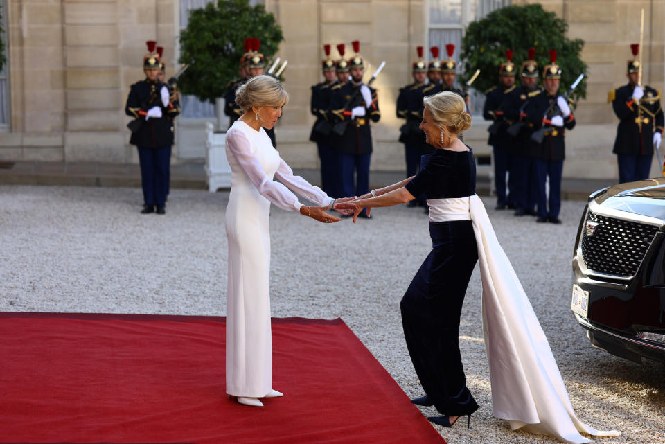Brigitte Macron welcomes US first lady Jill Biden in Schiaparelli velvet blue gown ahead of an official state dinner as part of US President's state visit to France on June 8, 2024 in Paris, France. 