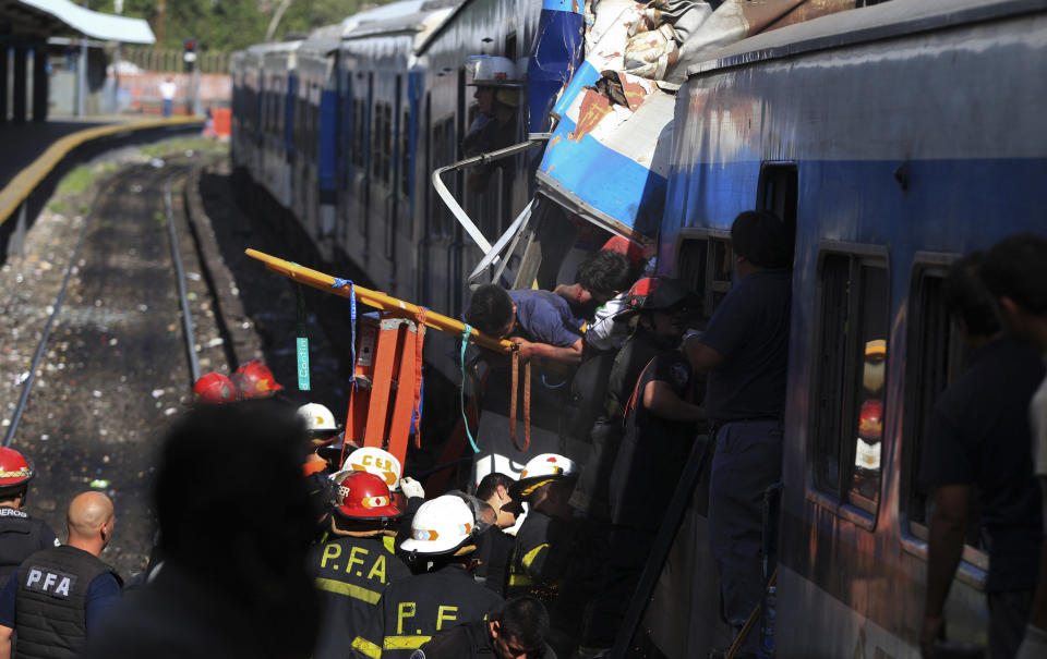 Firemen rescue wounded passengers from a commuter train after a collision in Buenos Aires, Argentina, Wednesday Feb. 22, 2012. A packed train slammed into the end of the line in Buenos Aires' busy Once station Wednesday, killing dozens and injuring hundreds of morning commuters as passenger cars crumpled behind the engine. (AP Photo/Anibal Greco) NO PUBLICAR EN ARGENTINA