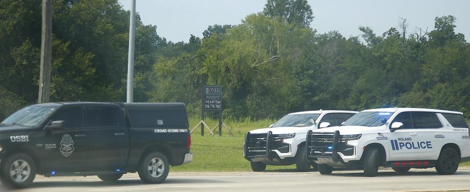 Oklahoma State Bureau of Investigation's crime scene vehicle is parked near Roland police vehicles Saturday in Roland, where eight gunshots were fired at a police officer. The officer was not hit by gunfire and a person was arrested nearby.