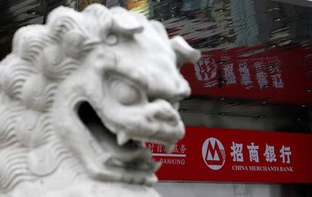 FILE PHOTO: A Chinese stone lion sits beside a branch of China Merchants Bank in Shanghai January 20, 2010. REUTERS/Aly Song/File Photo