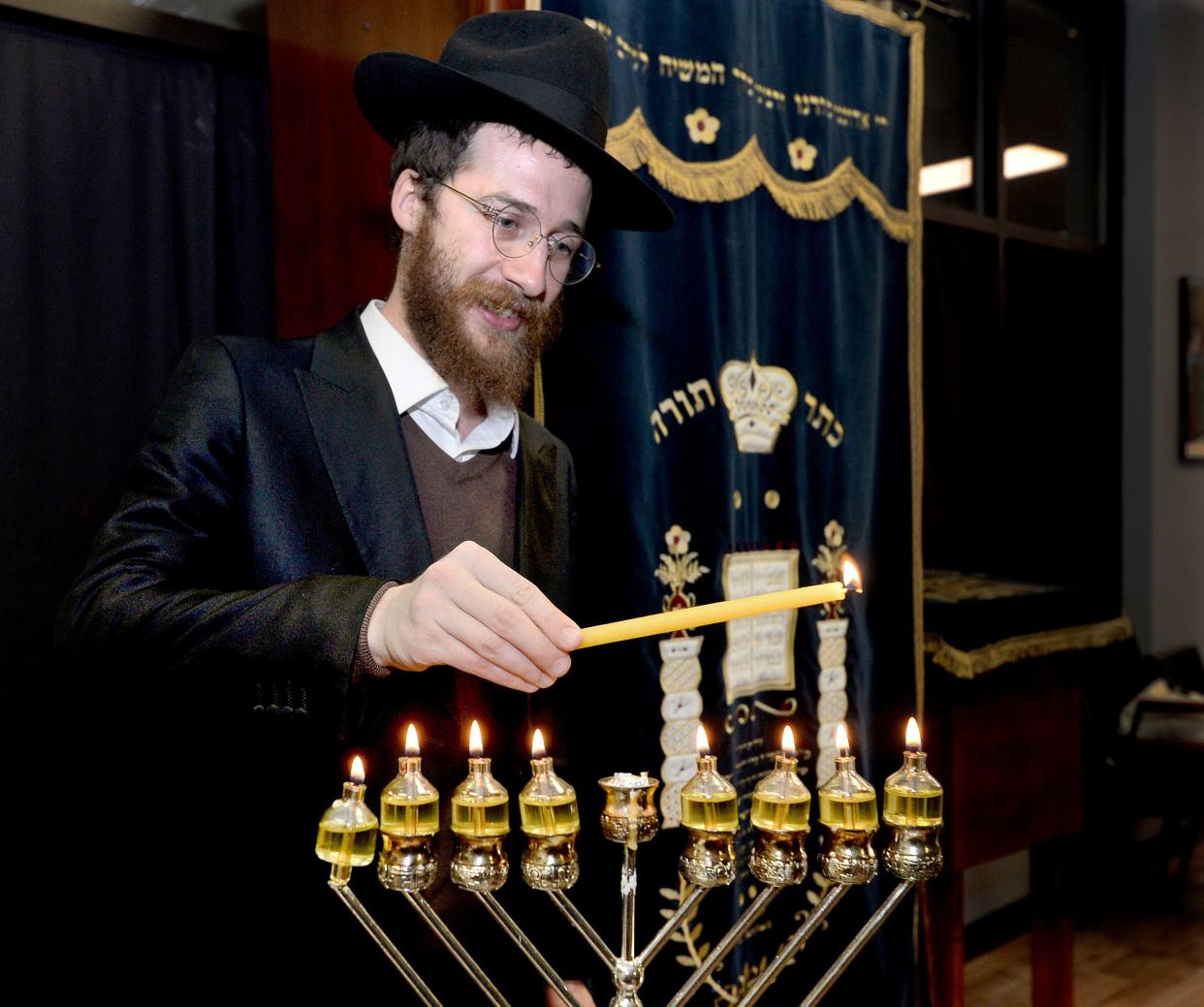 Rabbi Mendy Turen of Springfield lights a menorah at the Chabad Center on South MacArthur Boulevard on Tuesday.