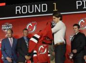 June 23, 2017; Chicago, IL, USA; Nico Hischier puts on a team jersey after being selected as the number one overall pick to the New Jersey Devils in the first round of the 2017 NHL Draft at United Center. Mandatory Credit: David Banks-USA TODAY Sports