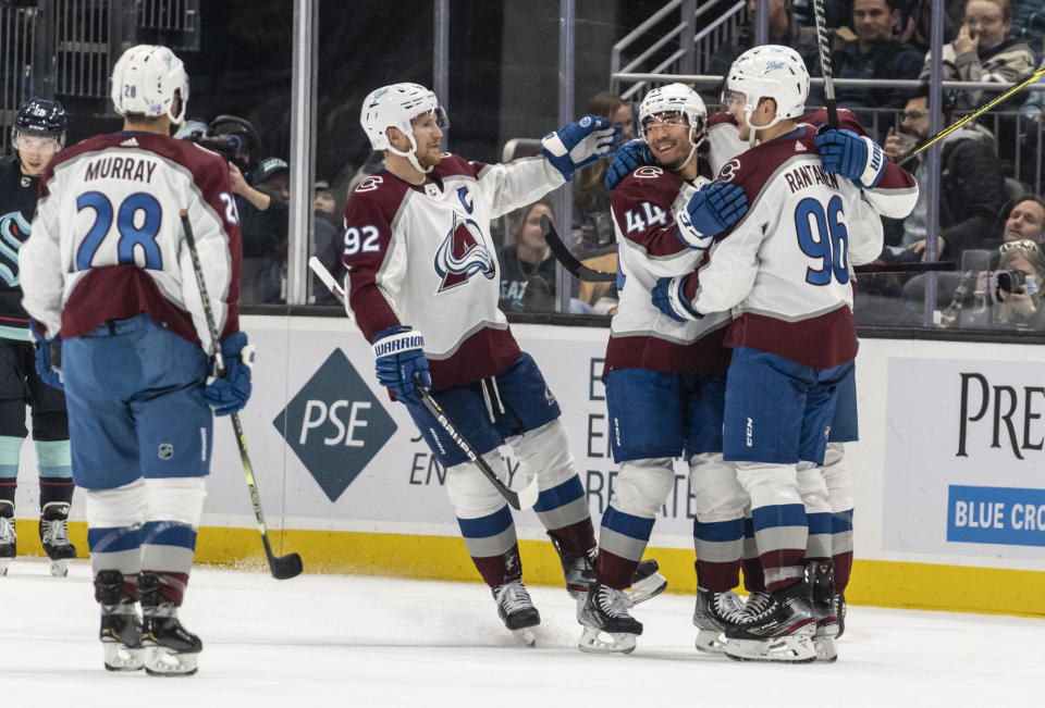 Colorado Avalanche including defenseman Ryan Murray (28), left wing Gabriel Landeskog (92), left wing Kiefer Sherwood (44) and right wing Mikko Rantanen (96) celebrate a goal during the second period of an NHL hockey game against the Seattle Kraken, Friday, Nov. 19, 2021, in Seattle. (AP Photo/Stephen Brashear)