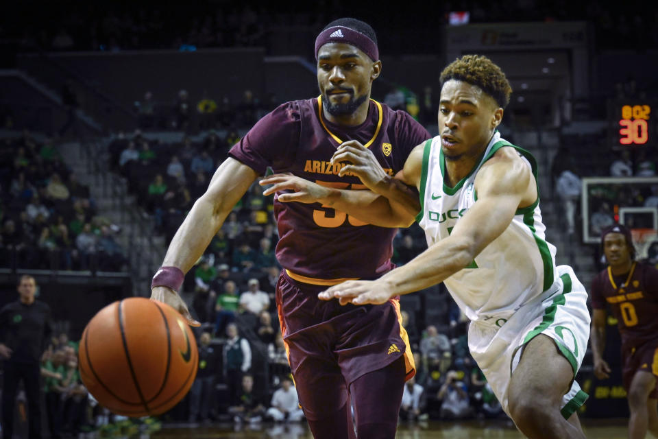 Arizona State guard Devan Cambridge, left, and Oregon guard Keeshawn Barthelemy, right, fight for control of the ball during the second half of an NCAA college basketball game Thursday, Jan. 12, 2023, in Eugene, Ore. (AP Photo/Andy Nelson)