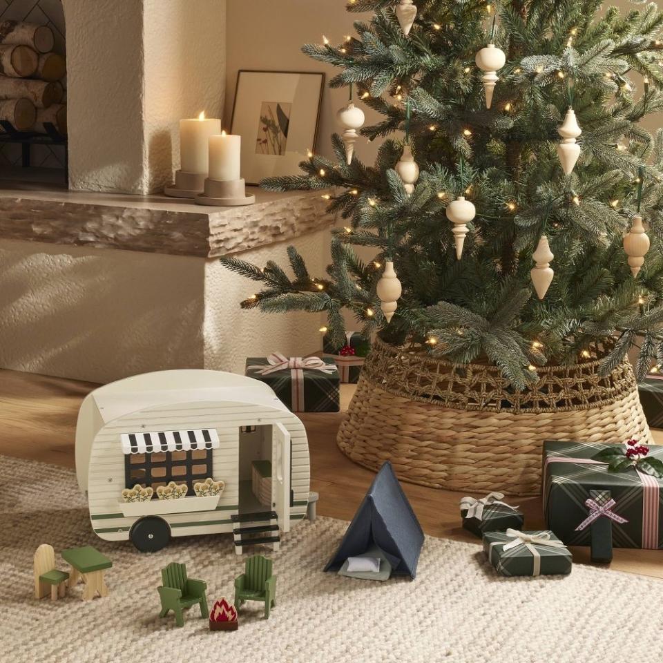 The tree collar on a tree with gifts and toys around it